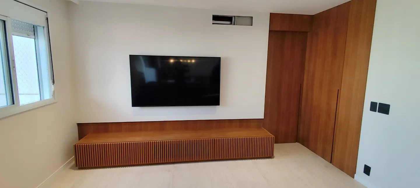 Rack suspenso ripado em madeira sob televisão em sala integrada